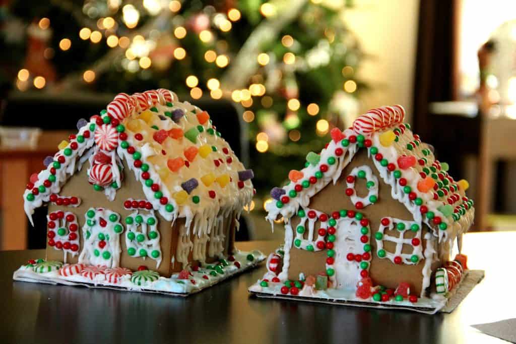 two gingerbread houses with blurred christmas tree in background