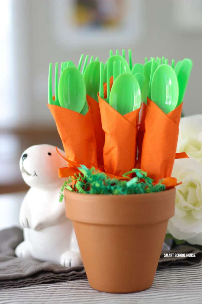 carrot napkin utensils wraps with green plastic cutlery and orange napkins in a terra cotta pot diy easter decoration