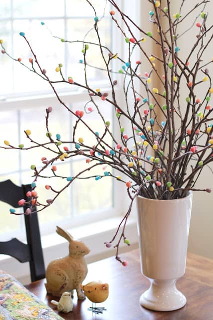 jelly bean tree branches in a white base on a table diy easter decoration