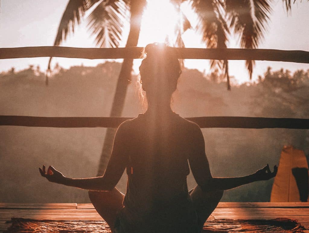 woman using meditation during sunrise to find serenity and find peace